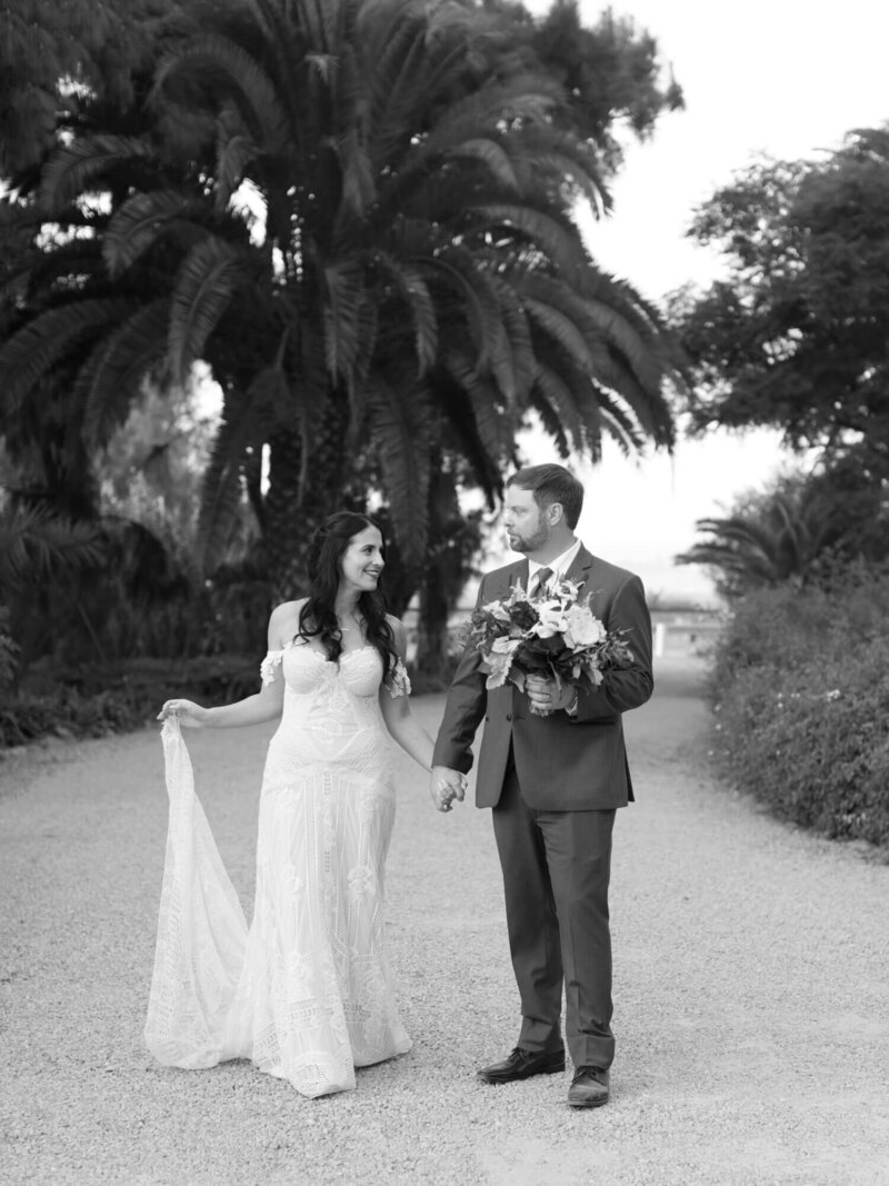 black and white walking photo of bride and groom at mccormick house wedding venue