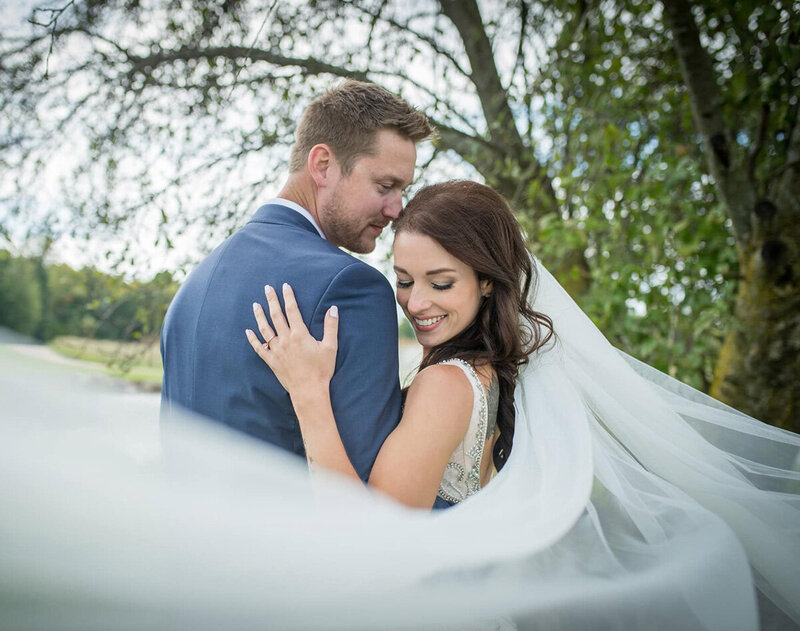 bride and groom with her veil blowing toward the camera