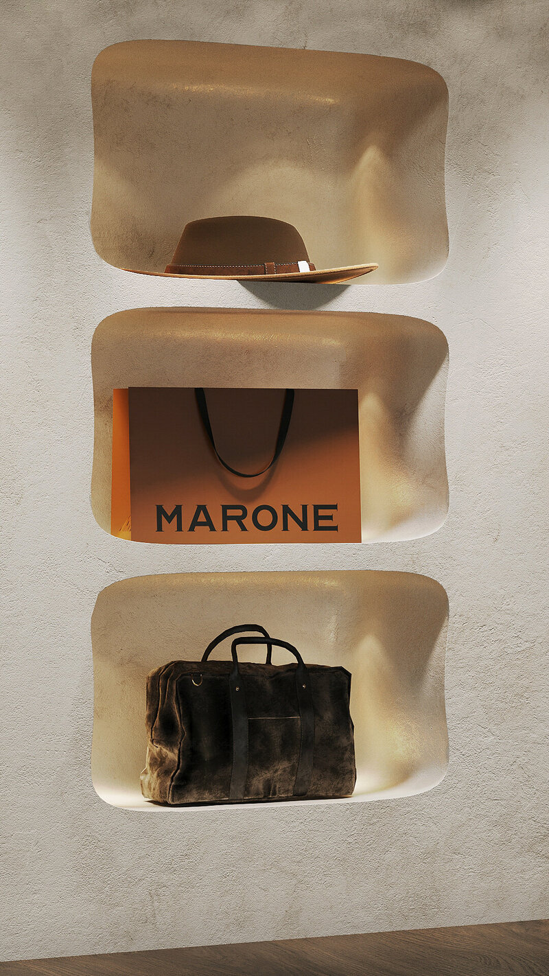 Marone brand display with suede travel bag, elegant hat, and signature shopping bag, highlighting luxury leather goods and timeless branding.