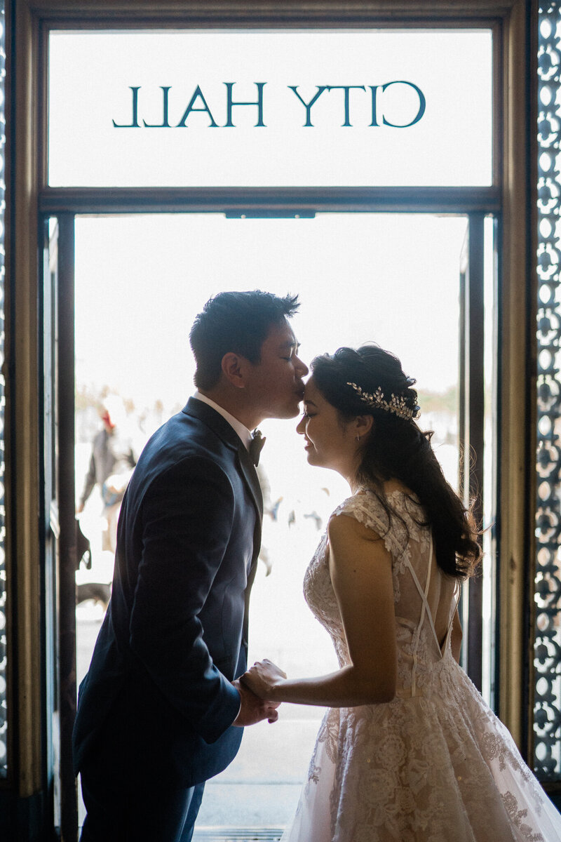 couple kisses after saying wedding vows at san francisco city hall