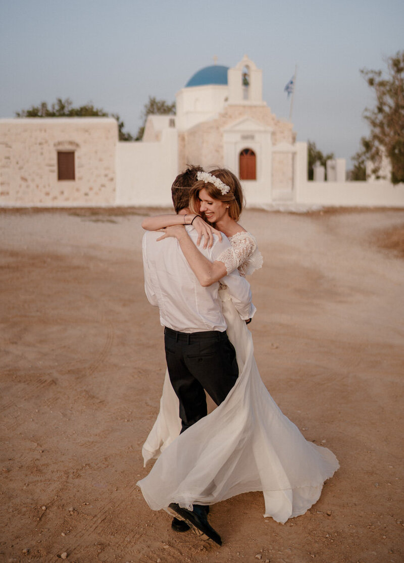 Destination wedding festif à Paros, en été, avec une séance couple près de l’église orthodoxe Agios Fokas – capté avec émotion par un duo photographe vidéaste