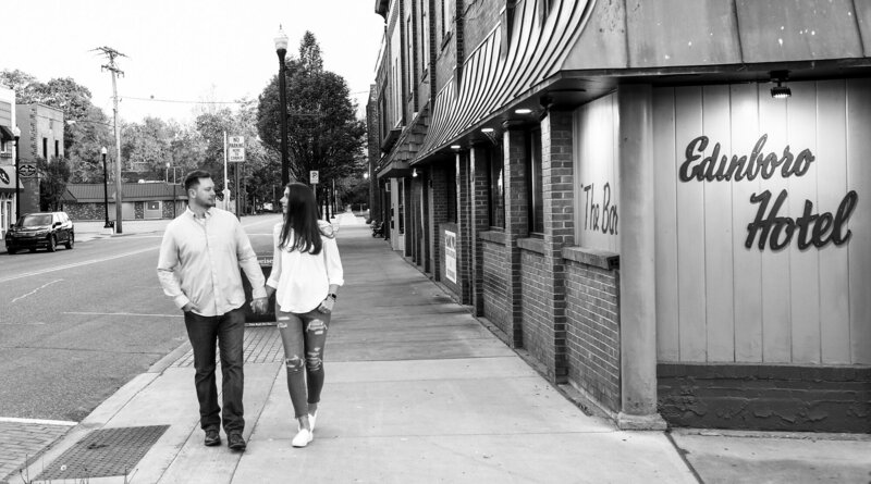 Engaged couple walk past the Edinboro Hotel bar