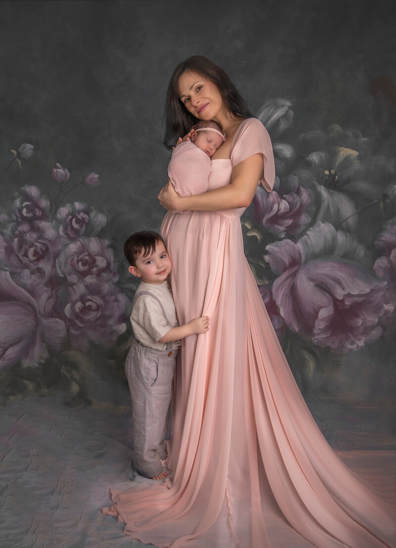"Mom, big brother, and newborn baby sharing a loving moment together, captured in a beautiful and serene family portrait session in Ottawa."