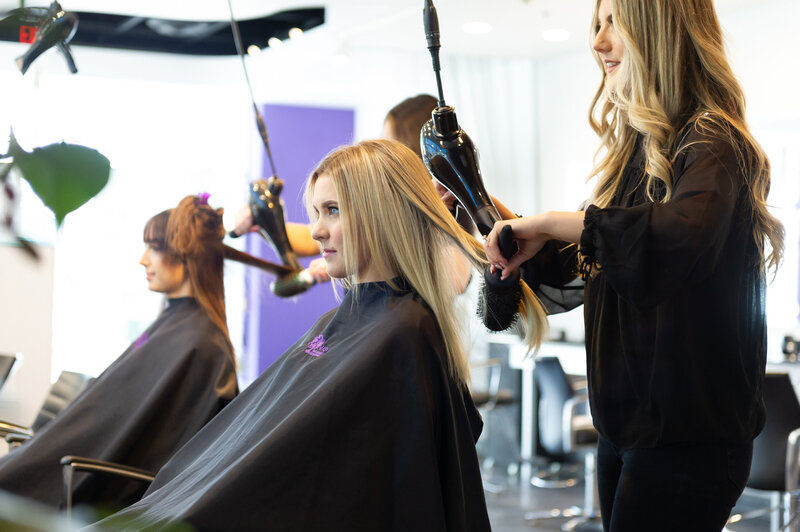 Vivd stylist styling client hair at blow dry bar