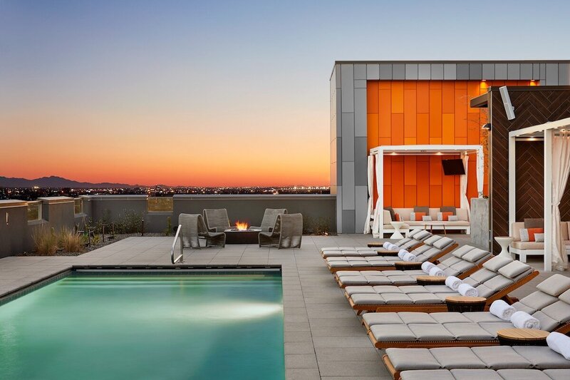 Rooftop pool with sun loungers, cabanas, and a modern firepit