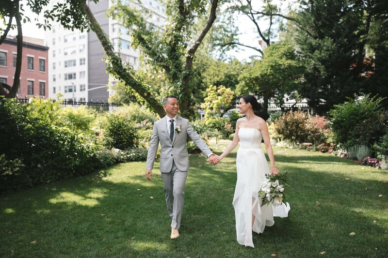 NYC elopement couple in central park kissing with flowers and san remo