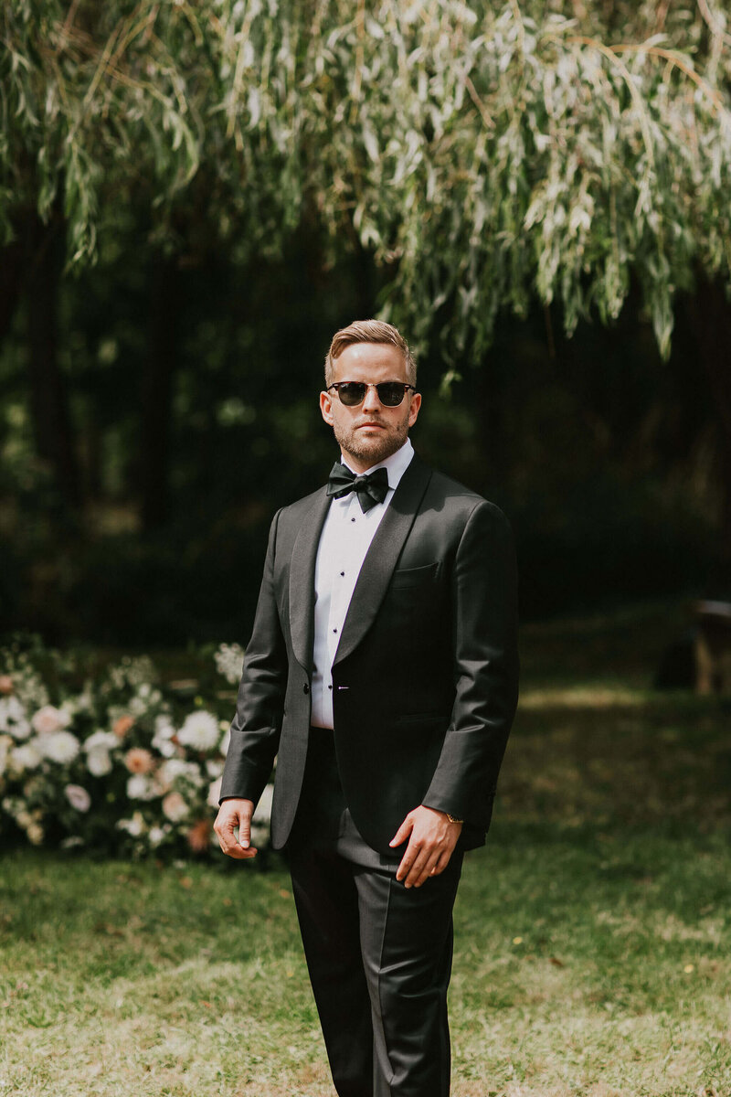 Groom in a black tux at Dewsall Court