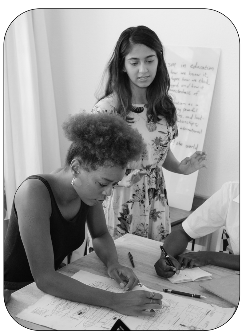 Black and white image of women sitting around a table coworking