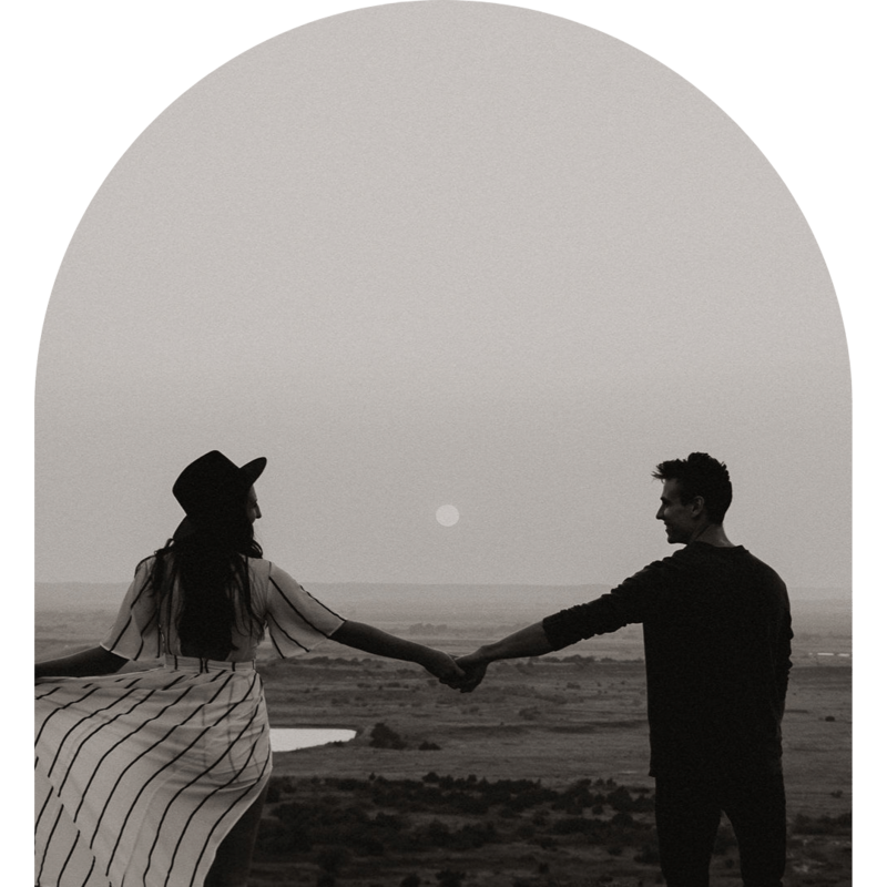 Couple holding hands looking out at the moon