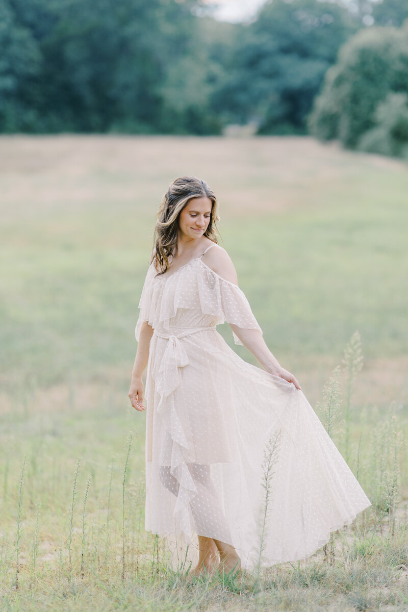 Woman smiling down at her dress in field