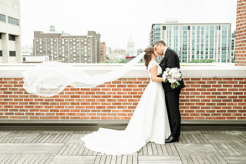 A bride and groom kissing downtown by Madison, WI wedding photographers Morgan Madeleine Photography