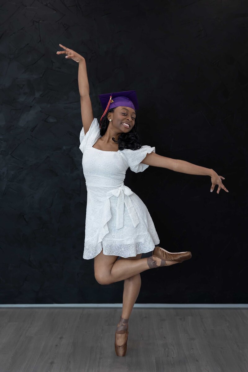 Creative senior photo of a graduated dancer striking a unique pose in a Dallas studio, part of a standout Senior Photography Portfolio.