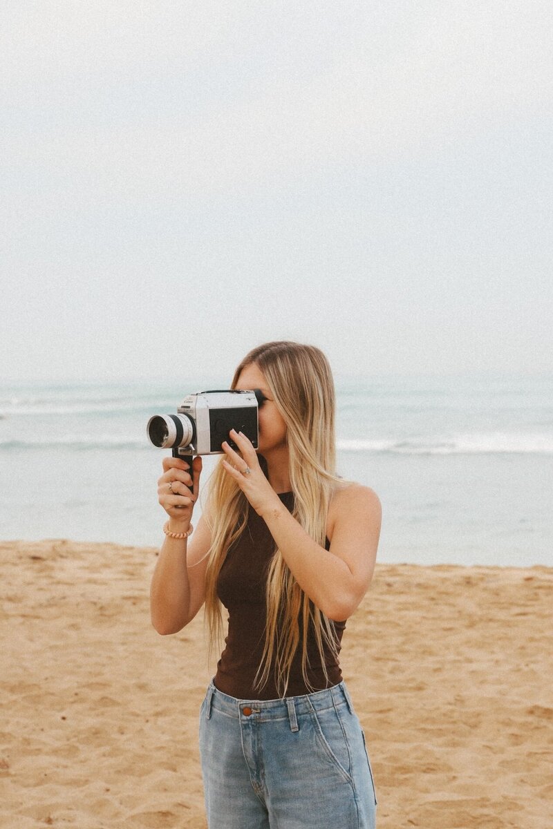 kylie films arizona and california wedding videographer on beach with camera