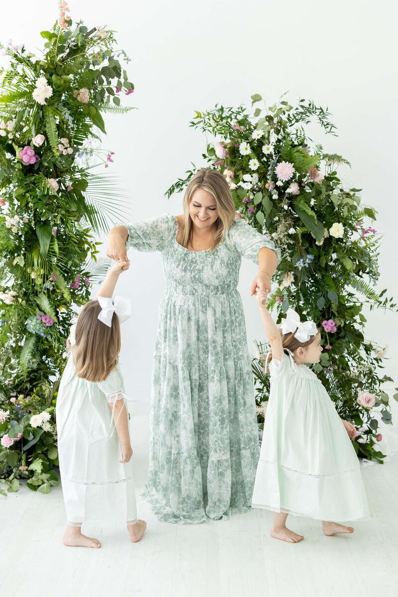 Woman spinning two daughters for mini model rep program photography