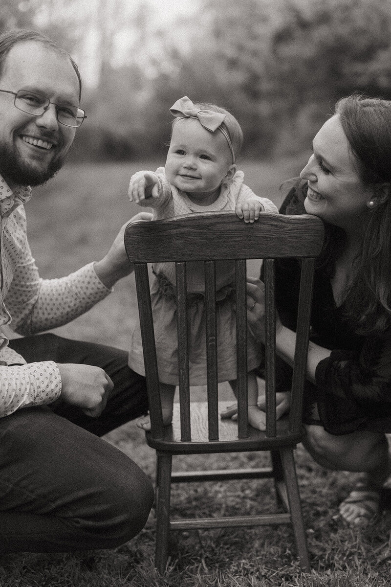 couple smiling with baby in center pointing during family photoshoot captured by NYC family photographer Elsie Goodman 