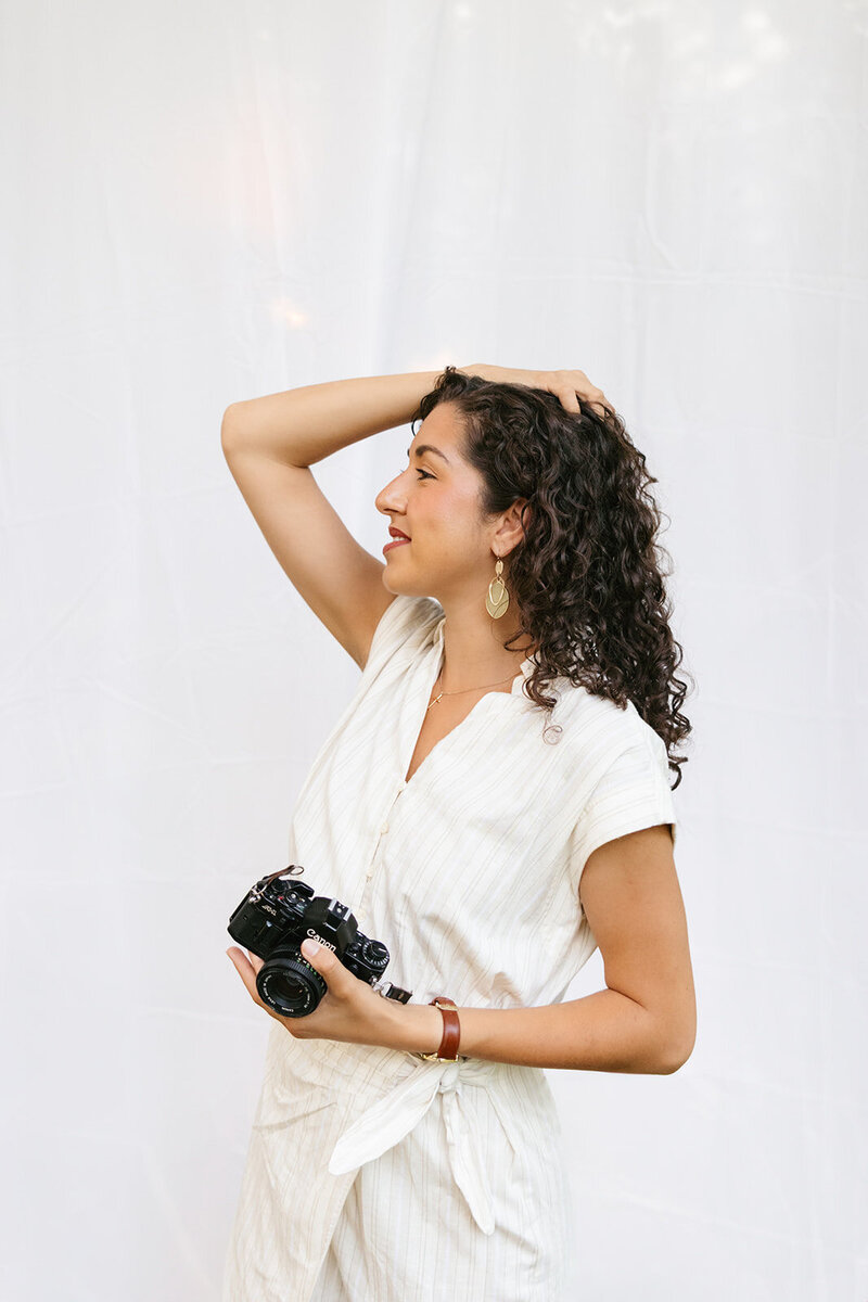 Headshot of Victoria Barclay, photographer at Through Victoria's Lens, holding her camera