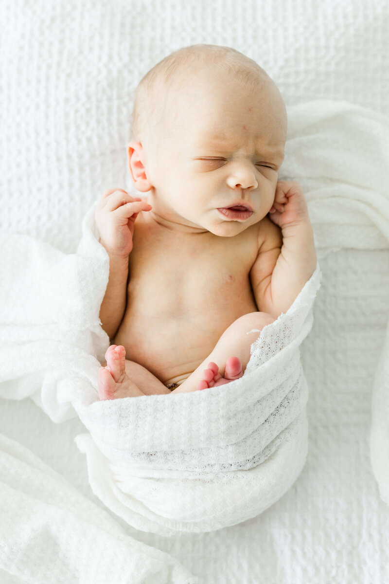 Baby wrapped in white wrap for newborn photography session in Dothan Alabama Photogrpahy Studio