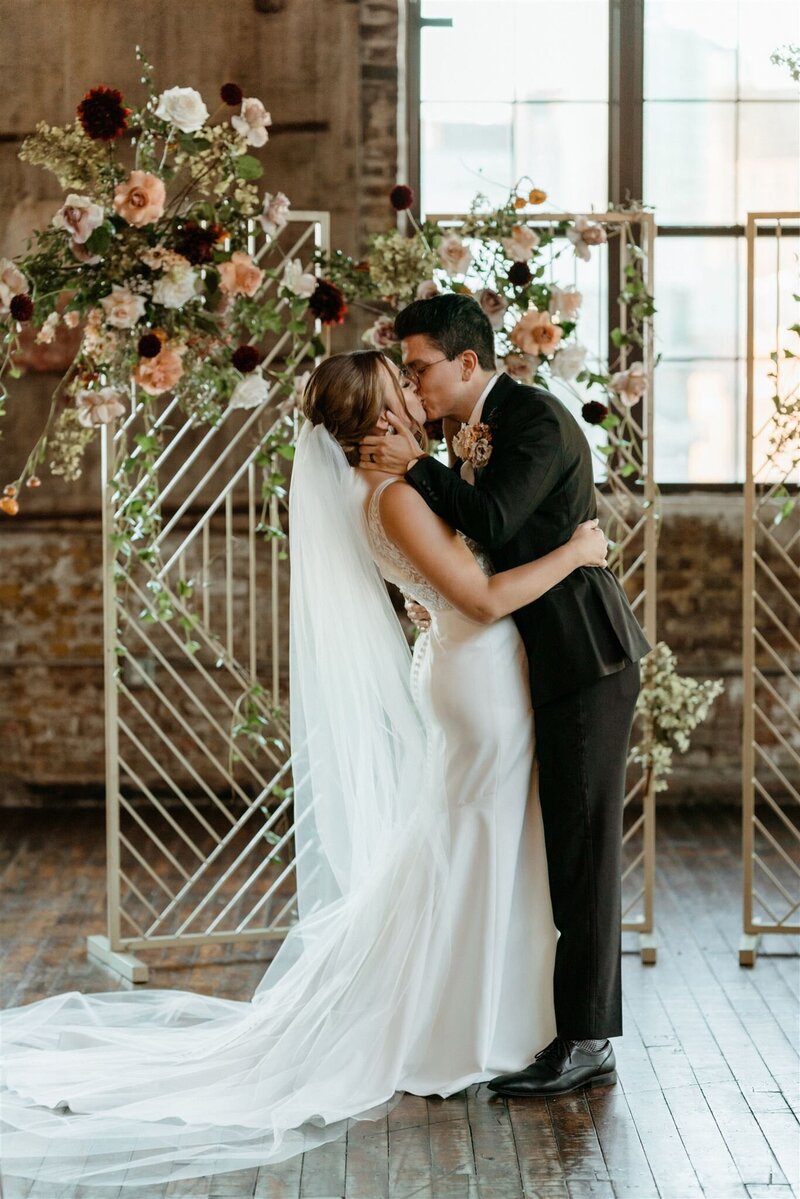 couple kissing during colorful editorial wedding