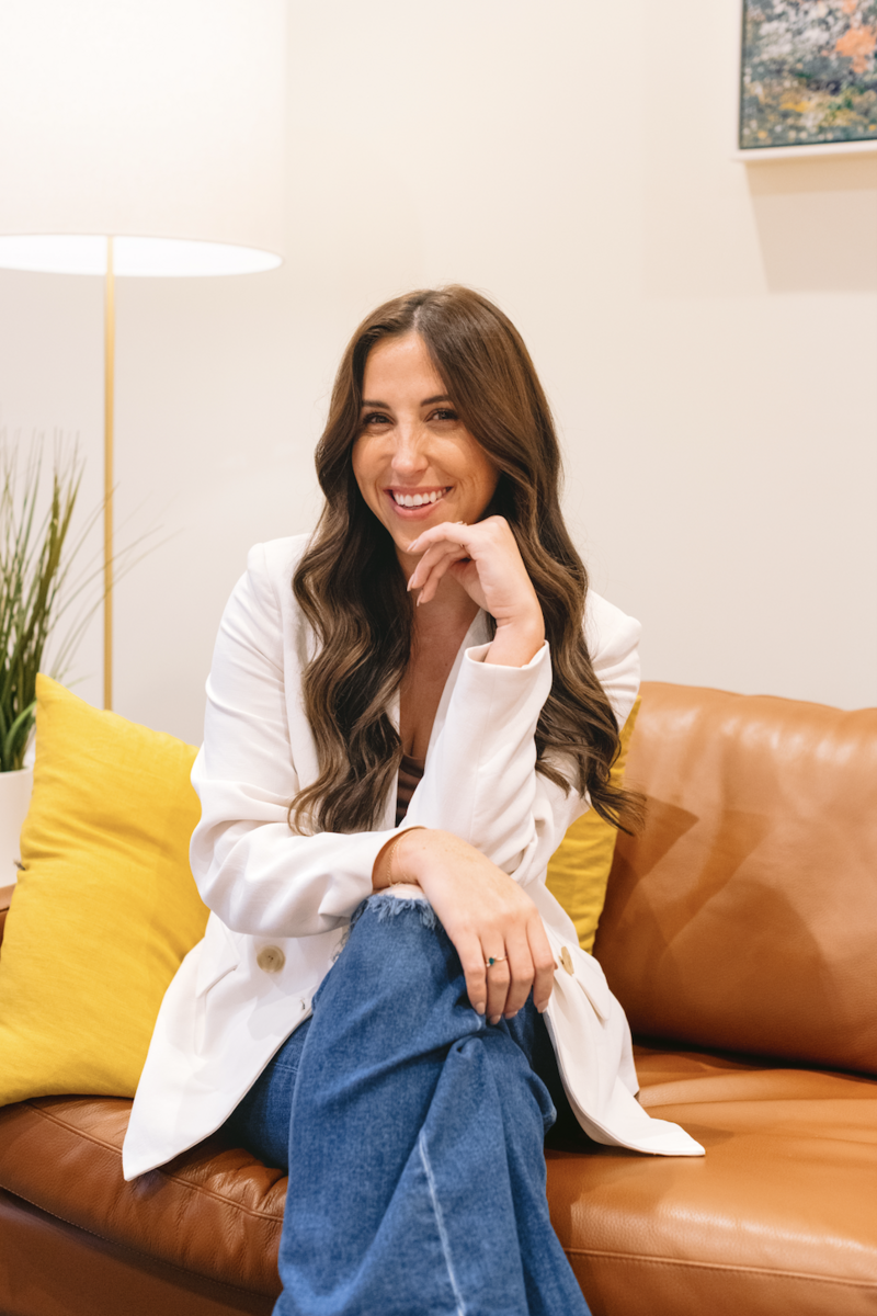 A girl with long brown curly hair smiling at the camera