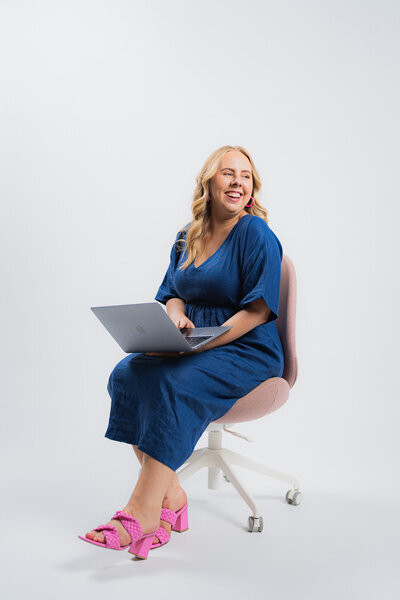 Amy sitting on a chair with her laptop working on business processes