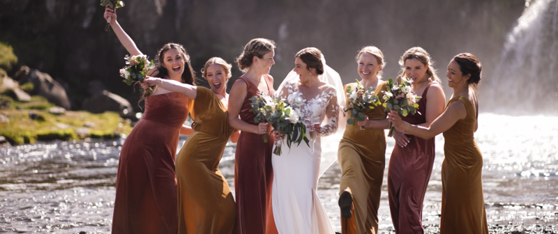 A screenshot from a wedding higlight video where bridesmaids are laughing together with the bride