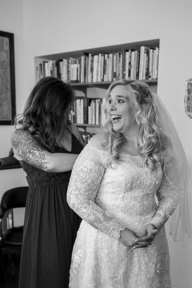 Bridesmaid zipping up bride's dress | Storybook Photography Wedding Photos