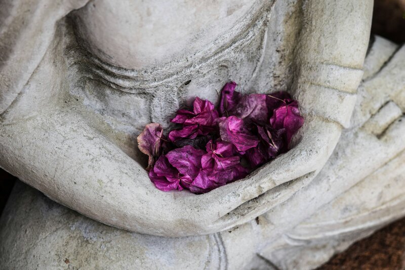 Buddah Statue holding pink flowers