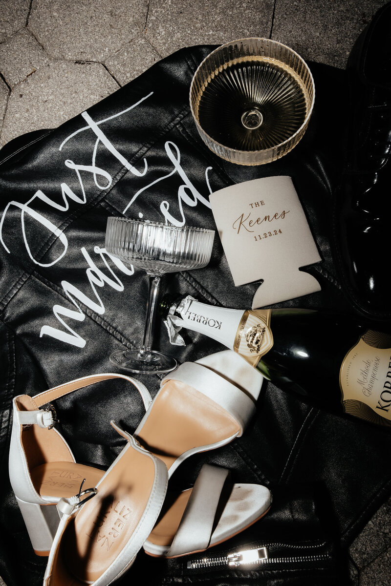 detail shot of brides jacket shoes and champagne