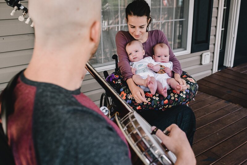 mom holding twin babies in wheelchair
