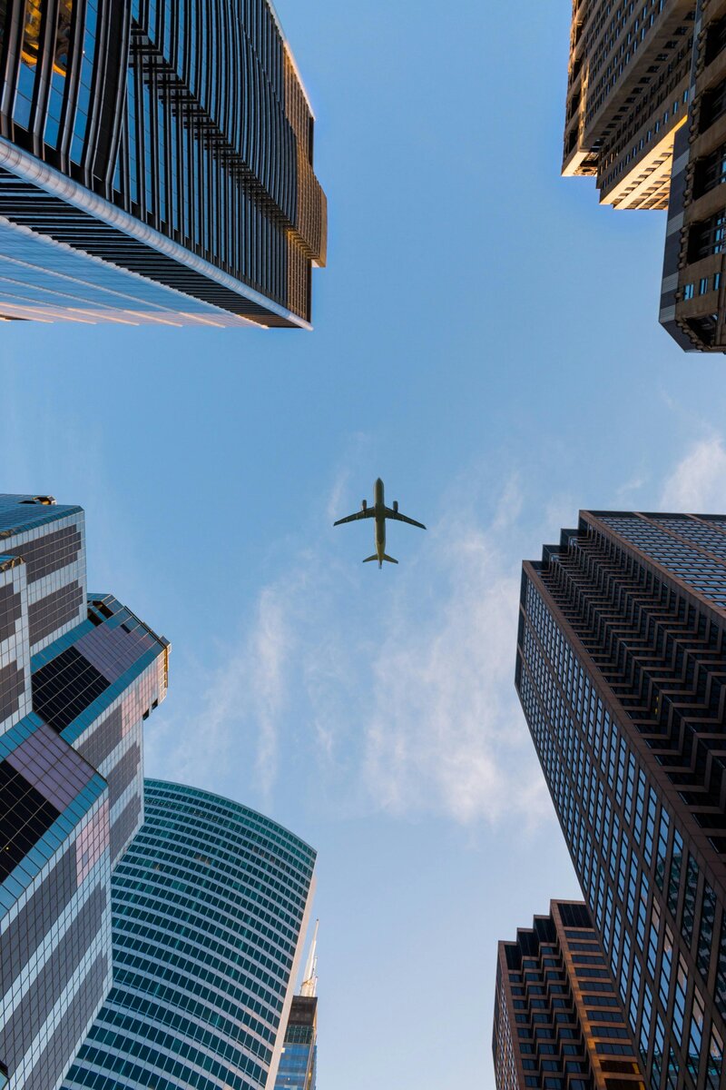 an airliner flies over downtown chicago skyscrapers on a sunny day