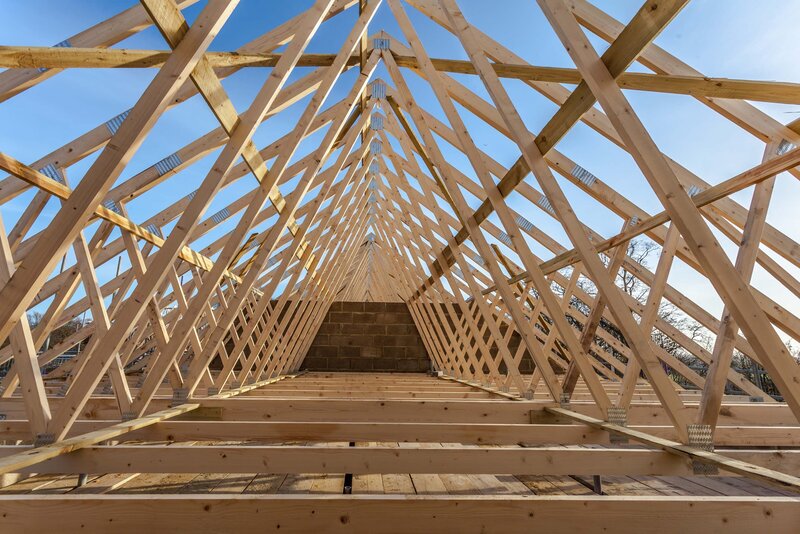 Wood trusses on roof against blue sky