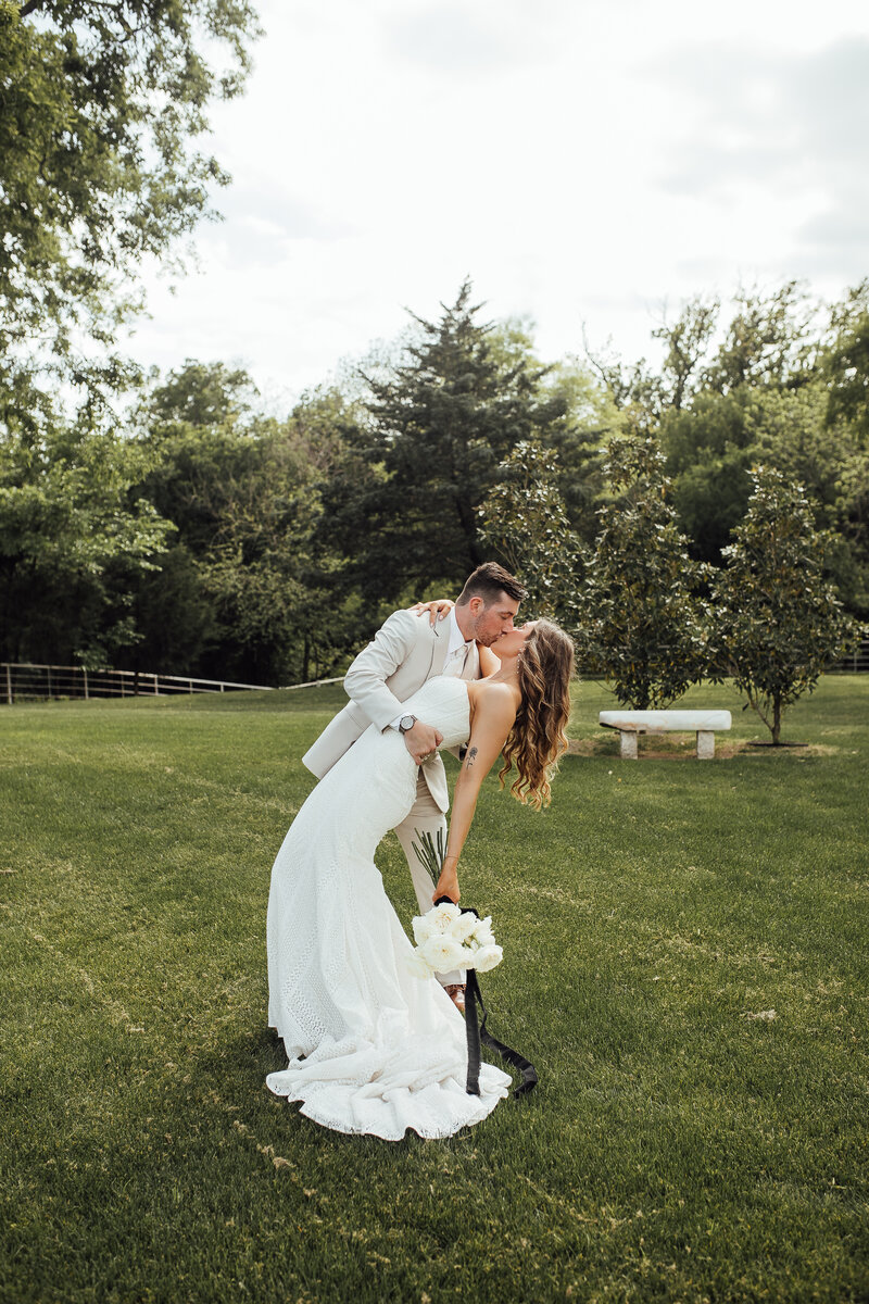 Groom dips bride for a kiss