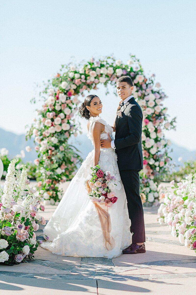 Bride and groom pose at outdoor wedding ceremony in CA.