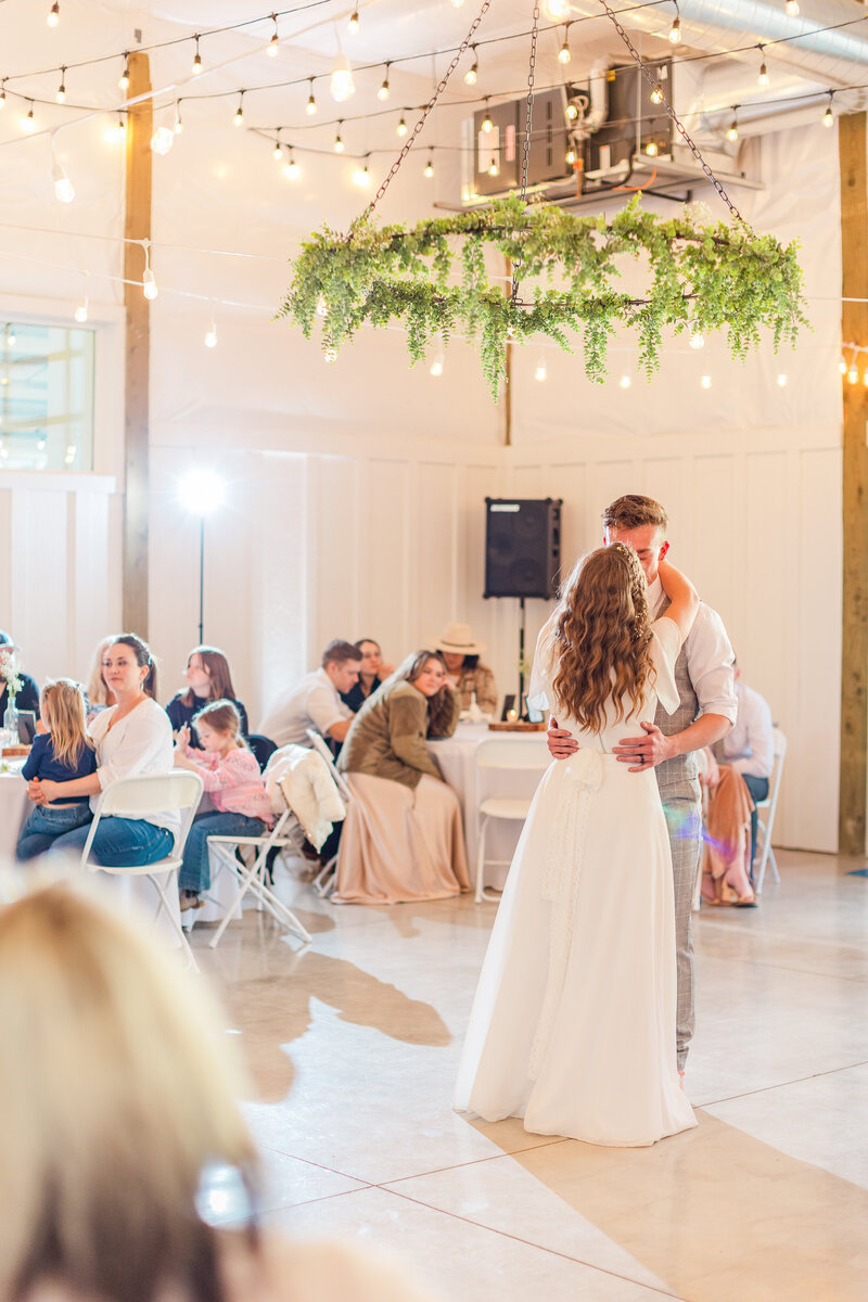 Young Couple has their first dance at reception in White Barn.
