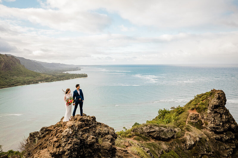 bride and groom holding hands on the edge of a cliff in california
