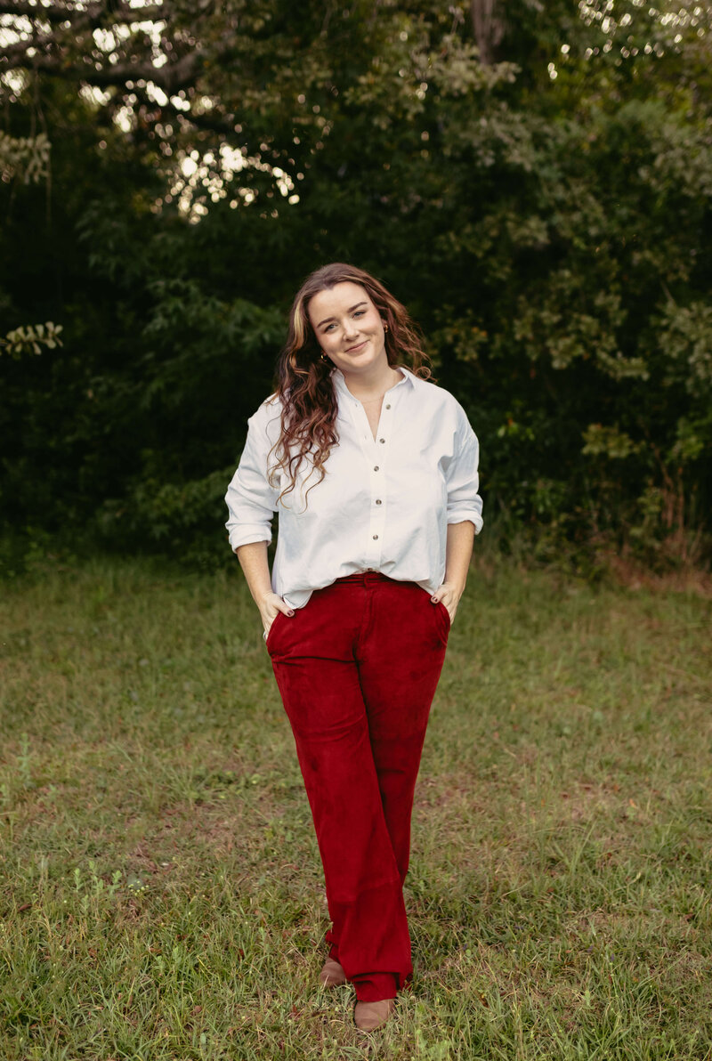 pcb photographer Brittney Stanley smiling at camera wearing white button up and dark red trousers