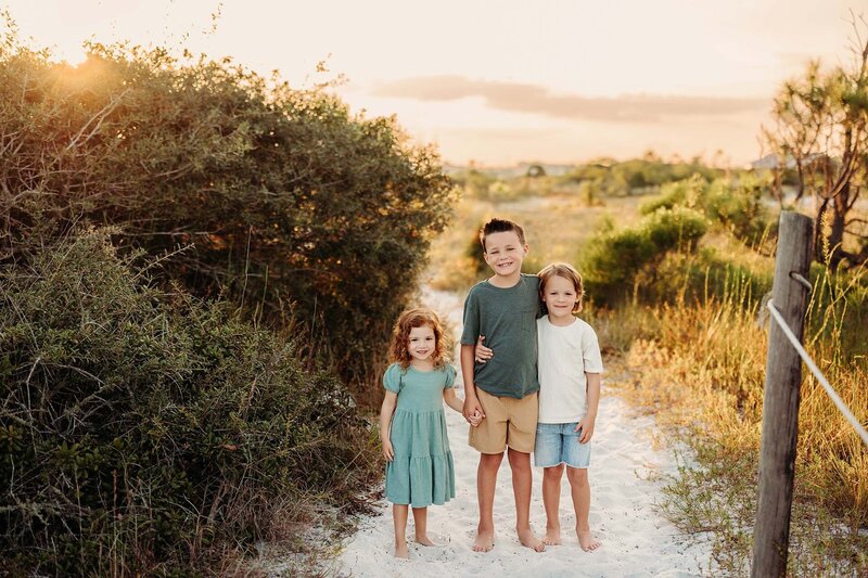 Jen Howell, Memphis professional newborn and family photographer, holds her son in a field at sunset.
