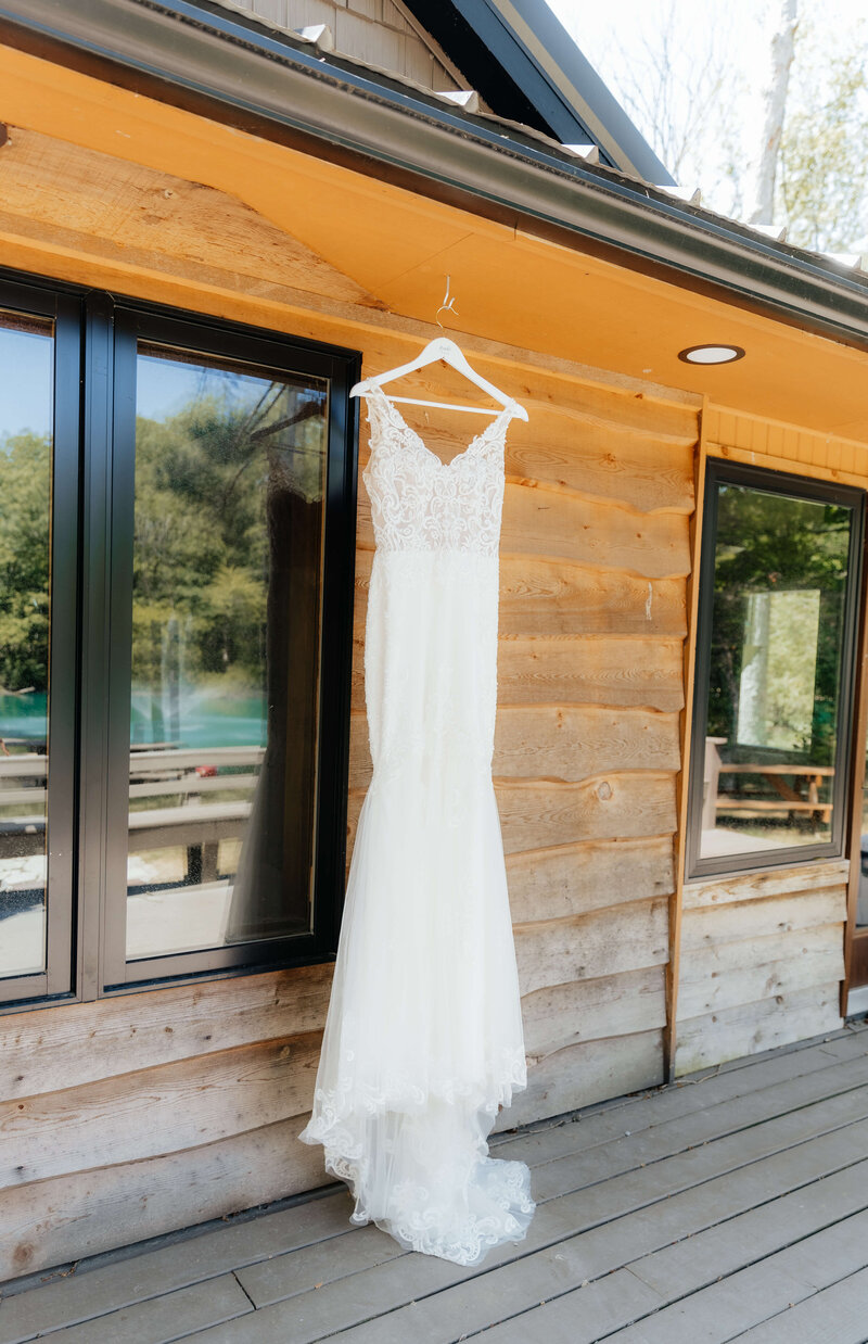 Detail shot of wedding dress at a Michigan cabin venue, captured by a storytelling photographer who highlights personal, intentional moments.