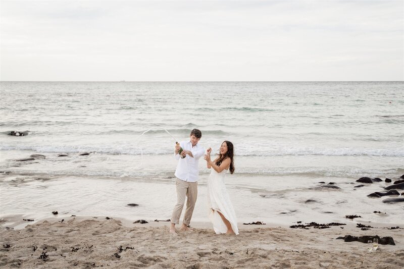 couple dressed in black walk along the rock formations at Yongmori Coast during their pre-wedding