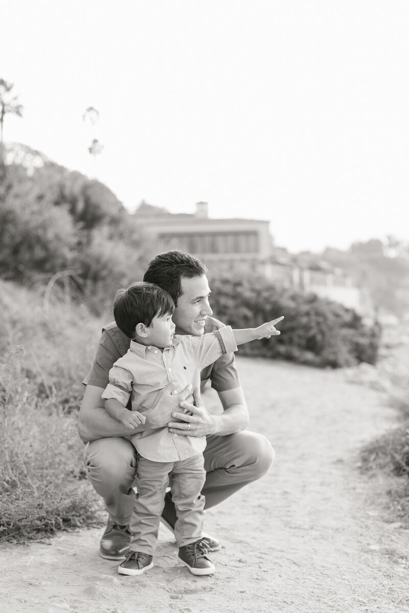 black and white portrait of dad and son looking out at the ocean in SoCal