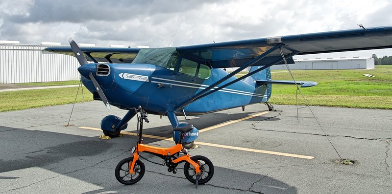 Orange Go-Bike M4 next to blue airplane