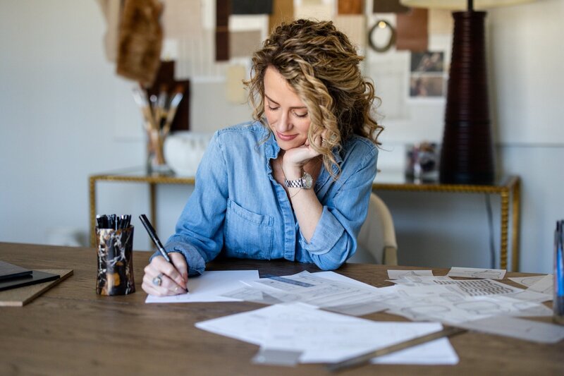 an interior designer writing notes at a desk