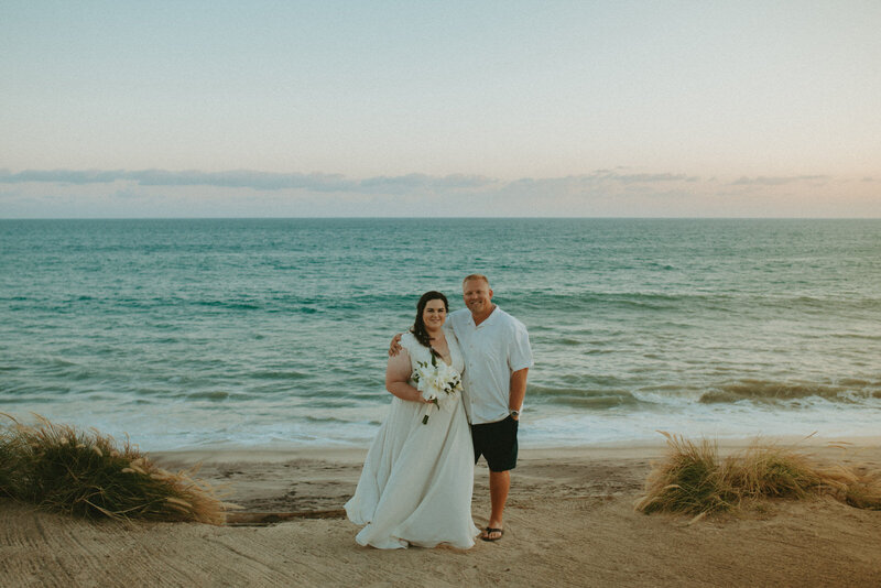 bride and groom kissing on sunset cliffs