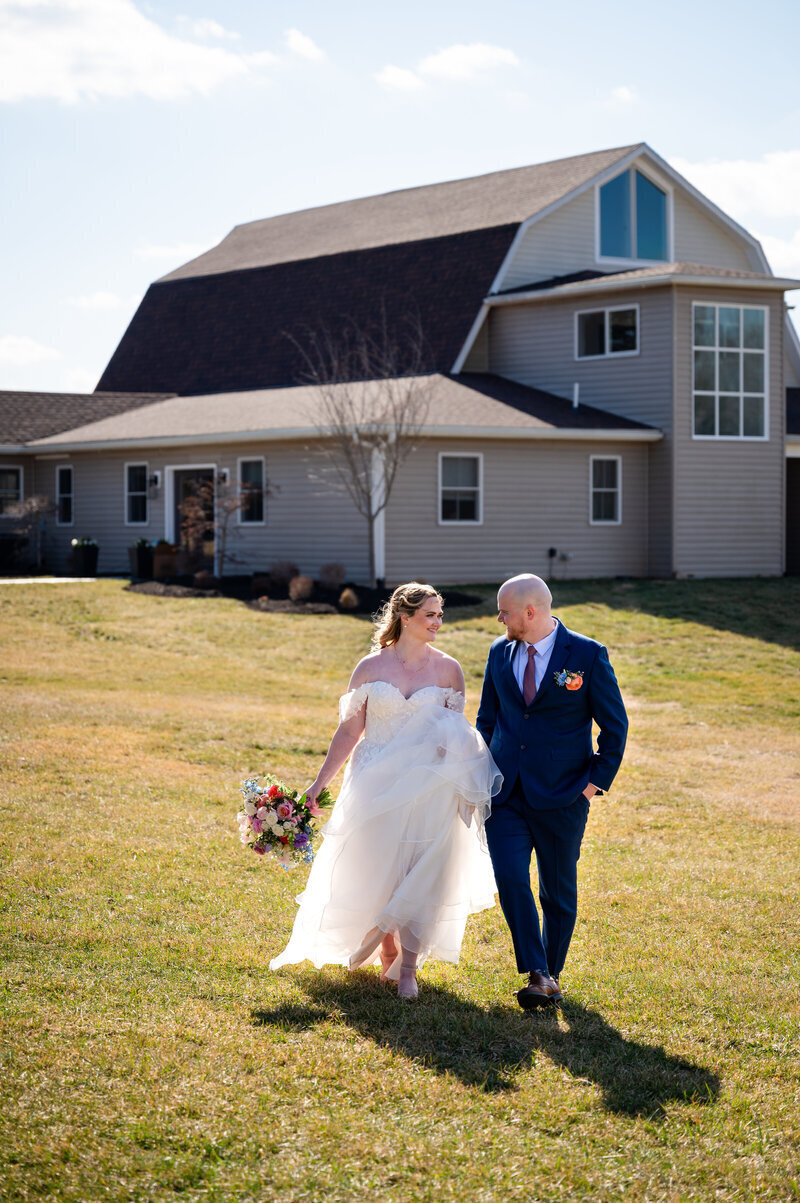 A bride and groom walk away from their barn wedding venue in Leesburg Va