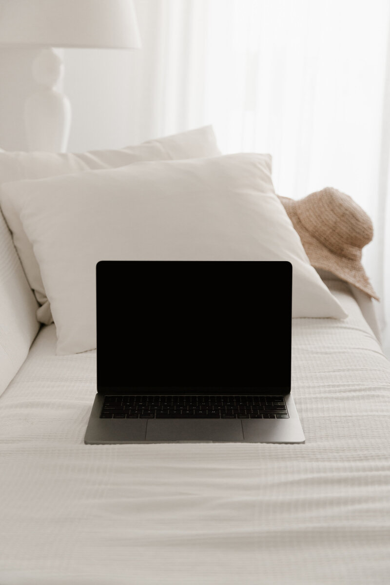 Grey laptop in front of a brown leather chair