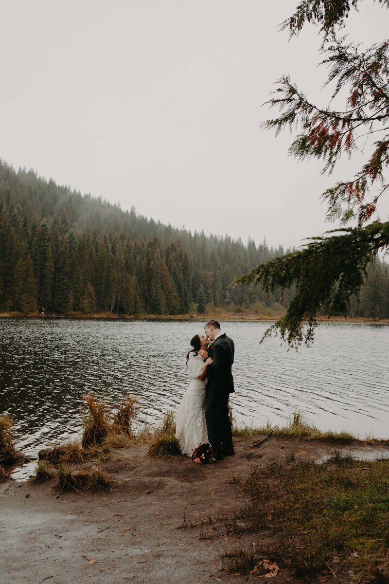 a mand and woman in wedding attire stand on the rocky beach shores of Yachats in Oregon