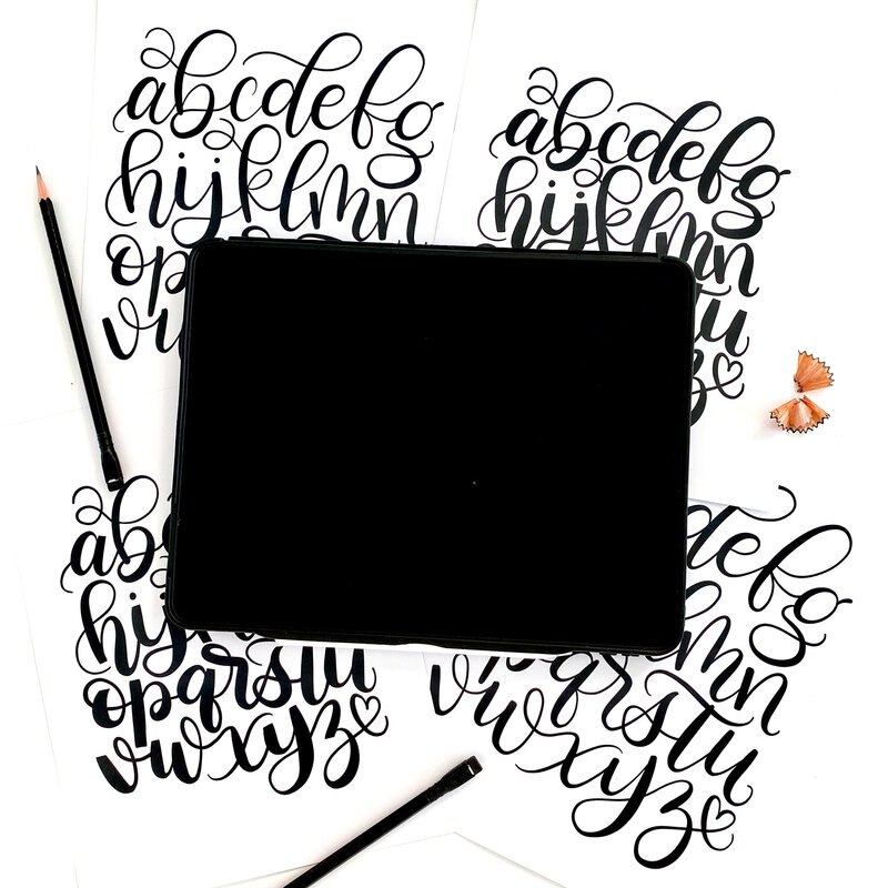 Black cursive hand lettering background with iPad mockup of Procreate App
