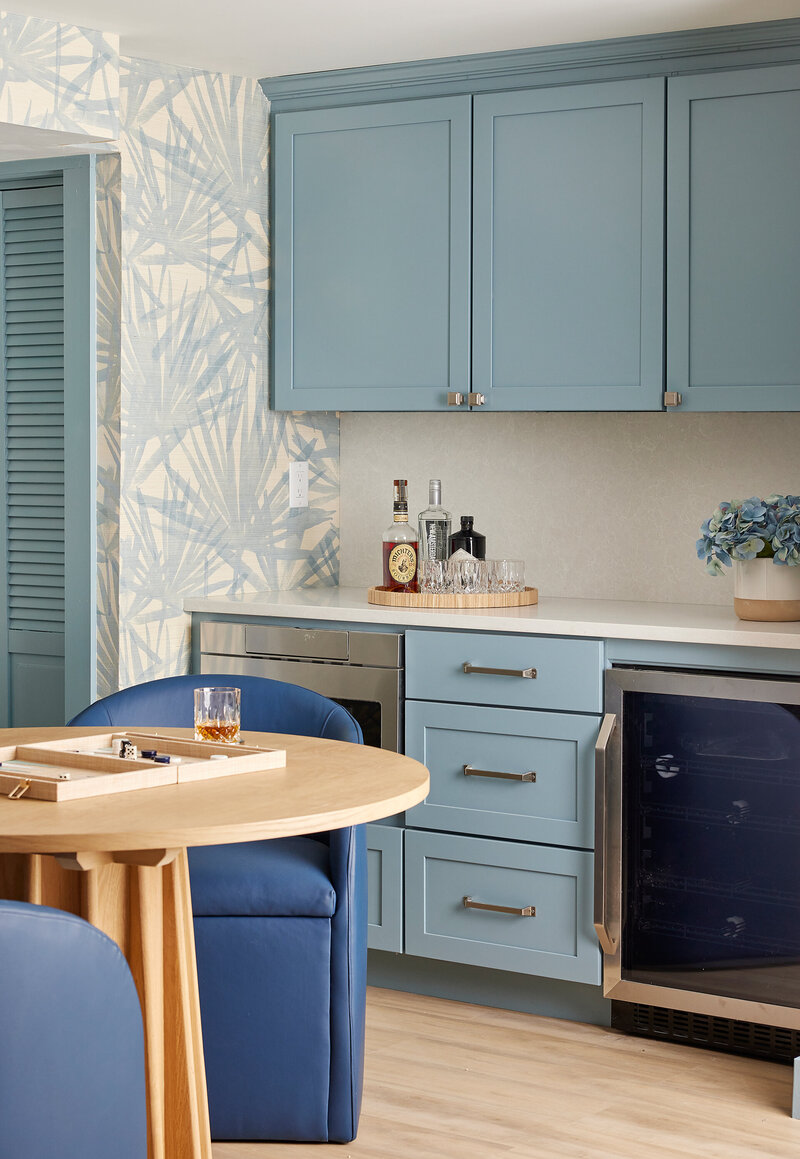 Contemporary kitchen with a mix of blue and white cabinets, wooden countertops, and stylish decor, creating a vibrant cooking space