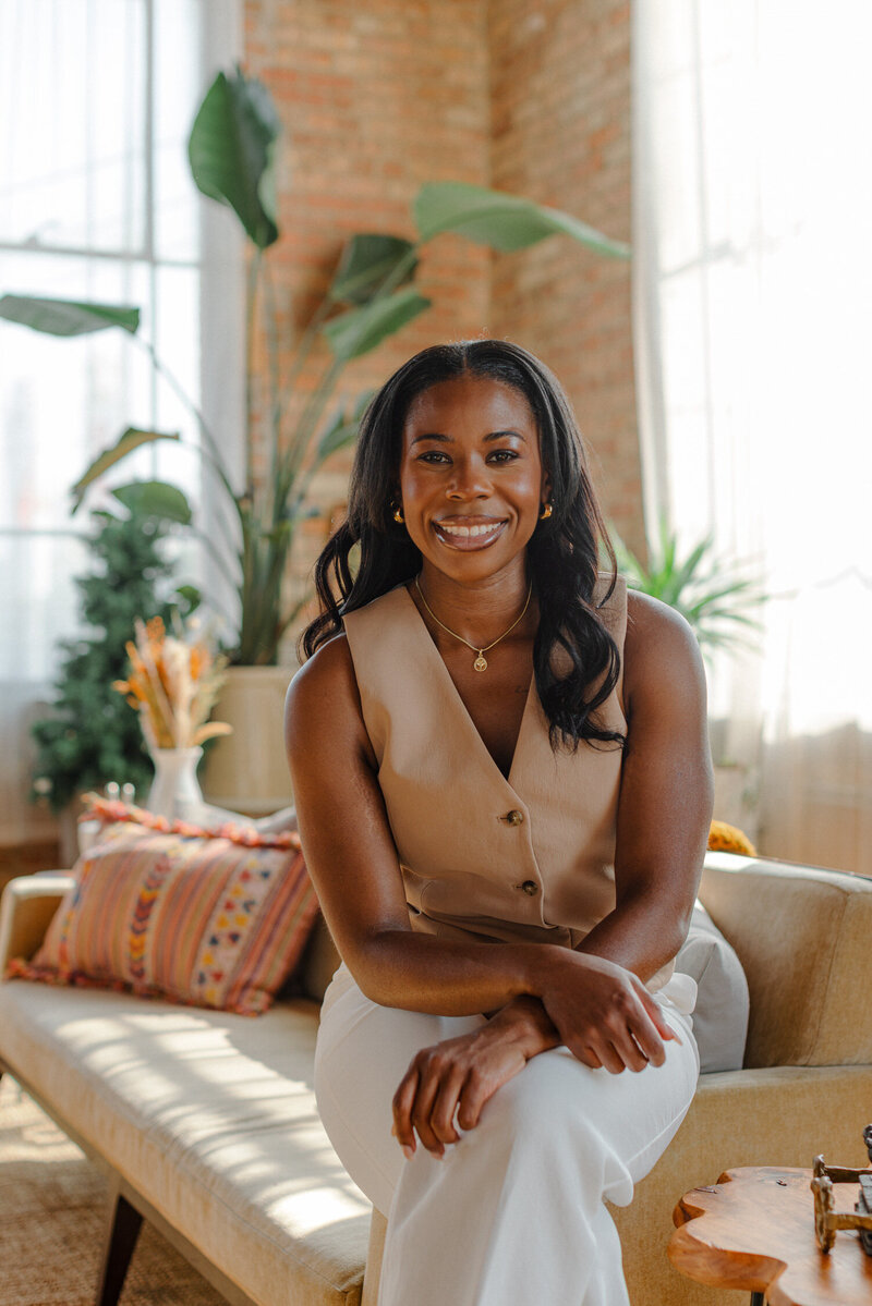 sex and relationship therapist Maia Easley smiling while sitting on a couch