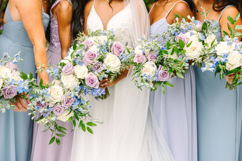 purple, white, and blue bride and bridesmaid bouquets